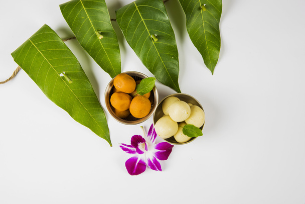 guirnalda de hojas de mango con pedha dulce indio y flor de orquídea. Es auspicioso en la religión hindú y se utiliza como decoración durante los festivales en la India
. - Foto, Imagen