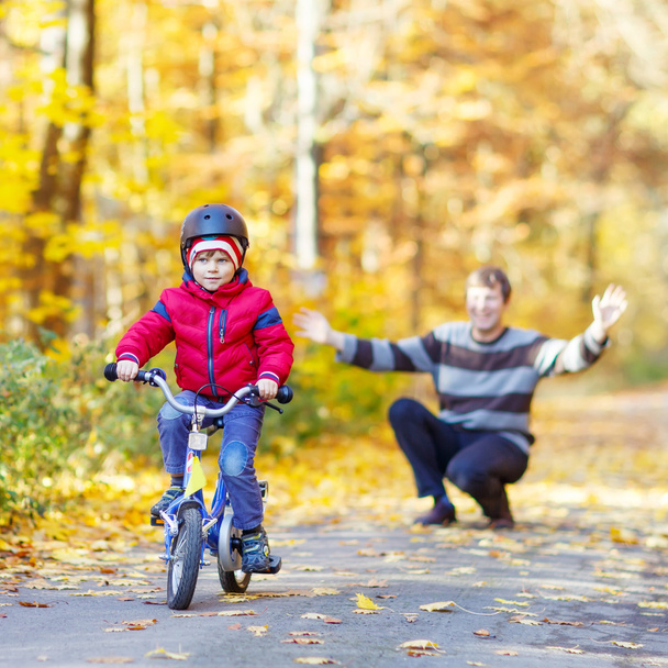 Menino e pai com bicicleta na floresta de outono
 - Foto, Imagem