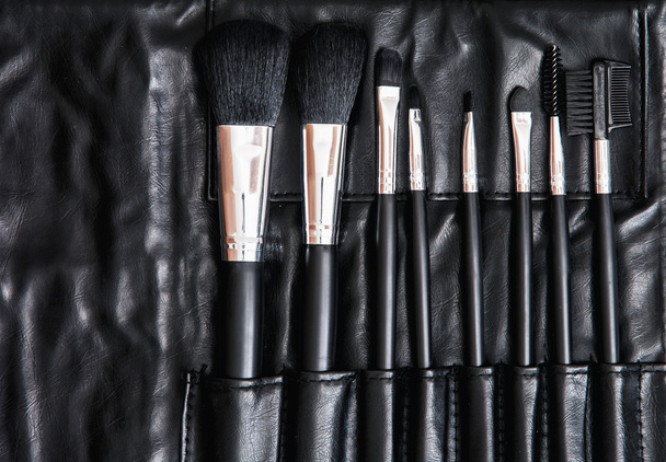 Set de cepillos cosméticos en bolsa de cuero negro, cuidado de la piel
 - Foto, Imagen