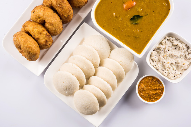 Sambar Vada & Idli con sambar, chutney di cocco e chutney di pomodoro rosso, piatto indiano servito in piatto bianco e ciotola su sfondo bianco
 - Foto, immagini