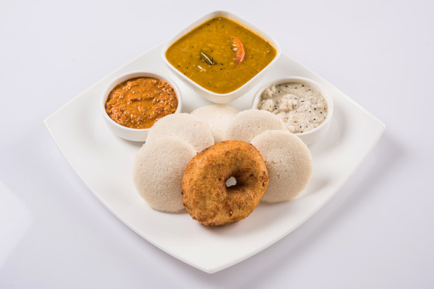 Sambar Vada & Idli con sambar, chutney di cocco e chutney di pomodoro rosso, piatto indiano servito in piatto bianco e ciotola su sfondo bianco
 - Foto, immagini