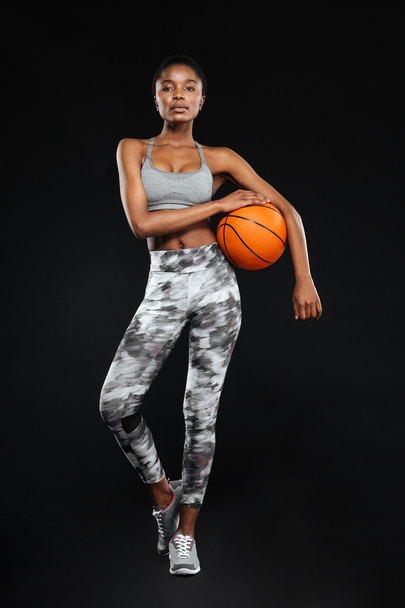 Full length portrait of a sports woman posing holding ball - Zdjęcie, obraz