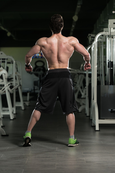Muscular Man Flexing Back Muscles Pose - Foto, imagen