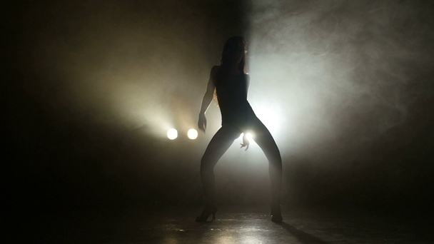 Σιλουέτα του ένα κορίτσι που χορεύει σχετικά με φόντο τα φώτα. Αργή κίνηση - Πλάνα, βίντεο