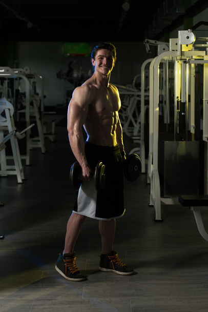 Young Man With Dumbbells Exercising Biceps - Foto, Imagem