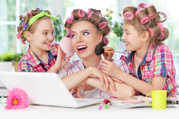 girls and mother  in hair curlers  with laptop - Foto, afbeelding