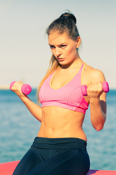 Woman doing sports outdoors with dumbbells - Photo, Image