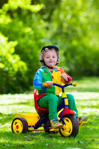 Little boy on colorful tricycle - Фото, изображение