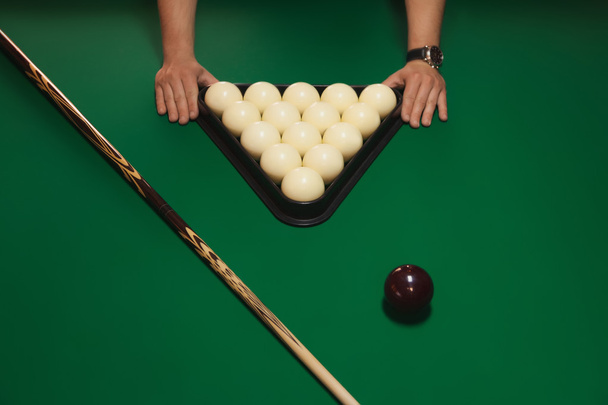 The order on the table. Balls neatly folded into a triangle. Details of the game of billiards. In the picture, there are men's hands. Billiard game concept. - Photo, Image