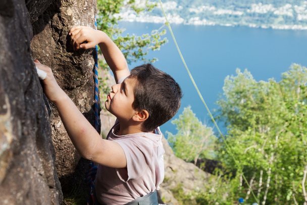 child climbs on rock wall - Foto, afbeelding