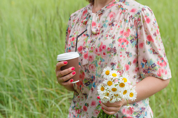 Женская рука с бумажной чашкой кофе на открытом воздухе, крупным планом
 - Фото, изображение