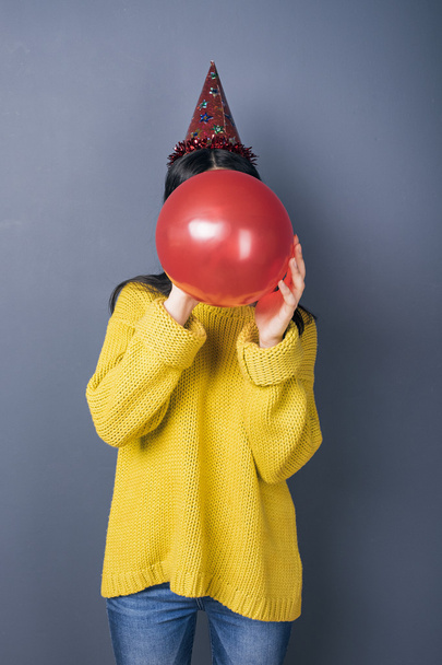 Black-haired girl blowing balloon - 写真・画像