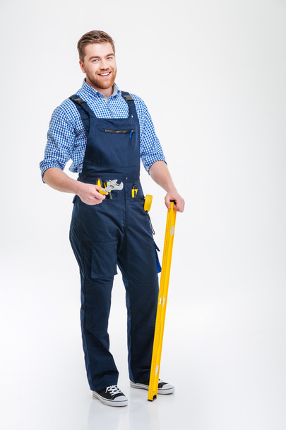 Happy male builder standing with equipment - Fotó, kép