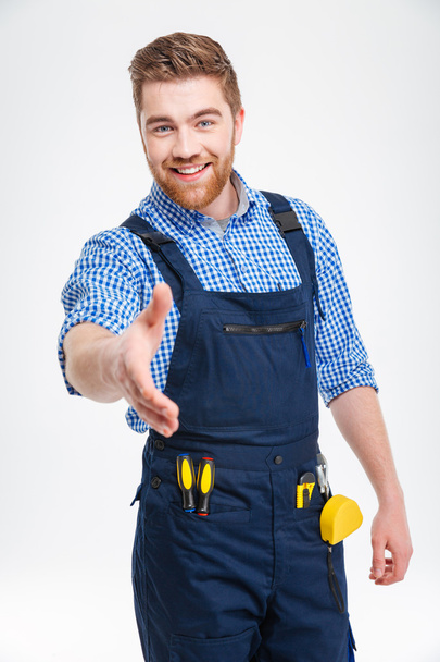 Happy male builder stretching hand for handshake - Photo, Image