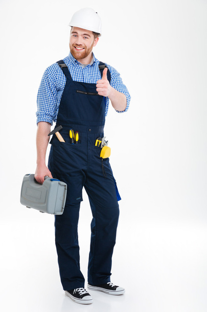 Happy builder holding tool box and showing thumbs up - Fotoğraf, Görsel