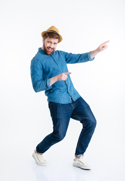 fröhlicher junger bärtiger Mann tanzt über weißem Hintergrund - Foto, Bild