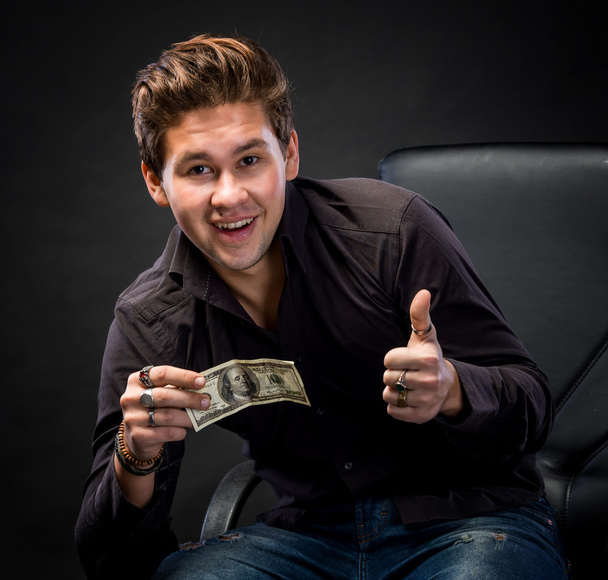 Щасливий молодий чоловік тримає гроші
 - Фото, зображення