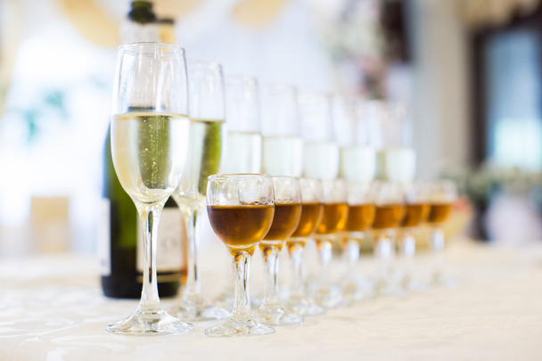 bril met Champagne op de witte tabel voor avond opvang - Foto, afbeelding