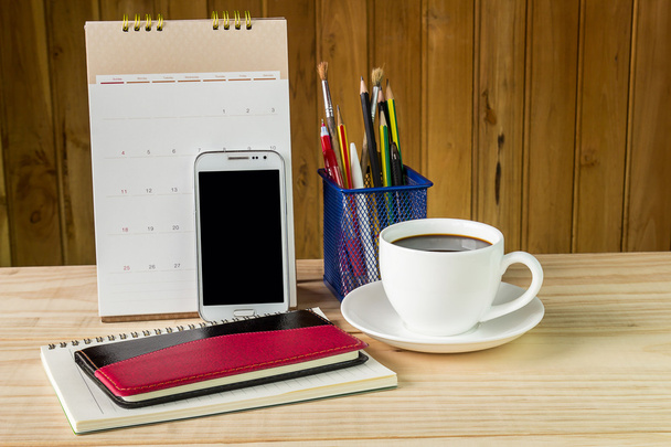 Carnet de notes, téléphone intelligent, tasse à café et pile de livres avec calendrier
 - Photo, image