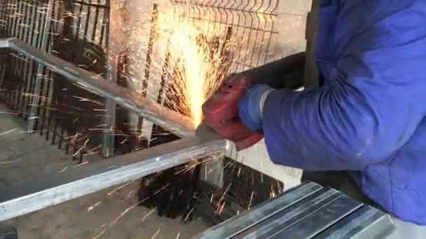 Pracovník pomocí průmyslové brusky na kovových dílů - Záběry, video