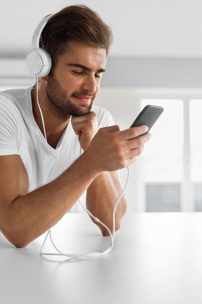 Music Listening. Man In Headphones Using Mobile Phone Indoors - Фото, зображення