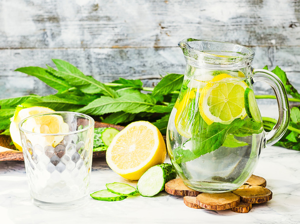 Víz citromos, menta és uborka üvegből, világos háttér  - Fotó, kép