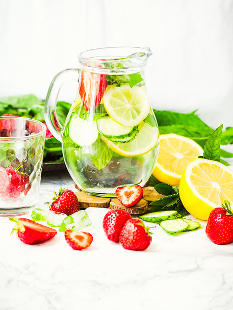 water-detox with lemon, strawberries and mint on light backgroun - Foto, afbeelding