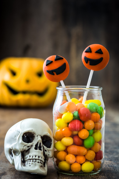 Gâteau d'Halloween pops et bonbons colorés sur fond de bois rustique
 - Photo, image