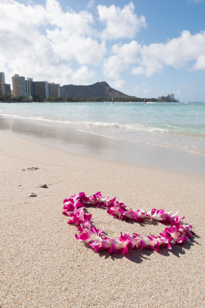 ορχιδέα λουλούδι Γκάρλαντ κολιέ σε σχήμα καρδιάς αγάπη στην άσπρη θάλασσα άμμο παραλία, ρομαντικό ζευγάρι μήνας του μέλιτος ταξίδι στη Χαβάη . - Φωτογραφία, εικόνα