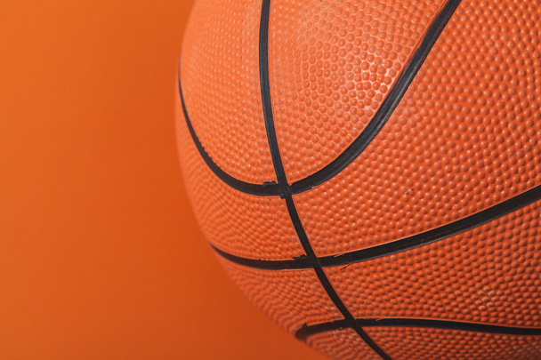 Basketbal op een oranje achtergrond - Foto, afbeelding