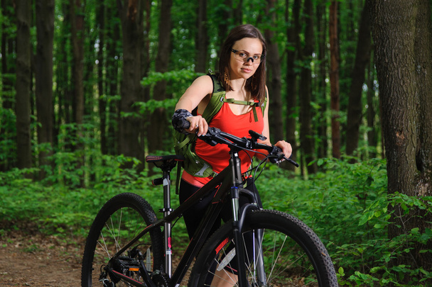 Girl riding a bike in the woods - Foto, afbeelding