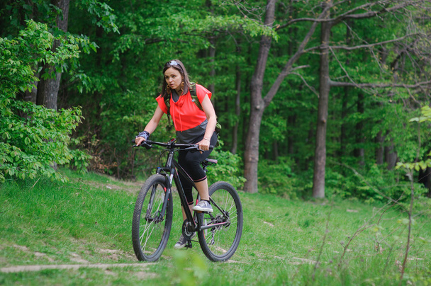 Girl riding a bike in the woods - Foto, Imagen
