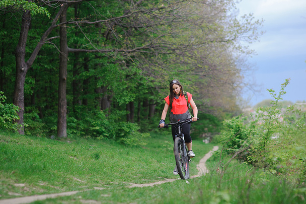 Girl riding a bike in the woods - 写真・画像