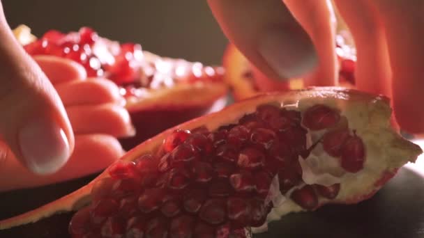 Beautiful female hands ripping pomegranate. Close up video - Materiał filmowy, wideo