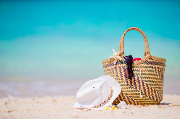 Plaj aksesuarları - hasır çanta, beyaz şapka, deniz yıldızı ve sahilde siyah güneş gözlüğü. Yaz plaj kavramı - Fotoğraf, Görsel