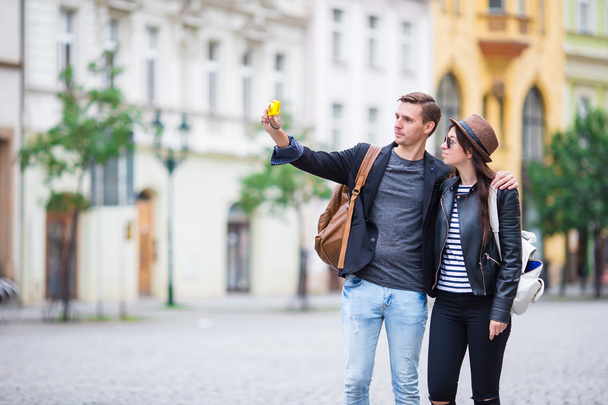 Selfie photo by caucasian couple traveling in Europe. Romantic travel woman and man in love smiling happy taking self portrait outdoor during vacation holidays in Prague - Photo, Image
