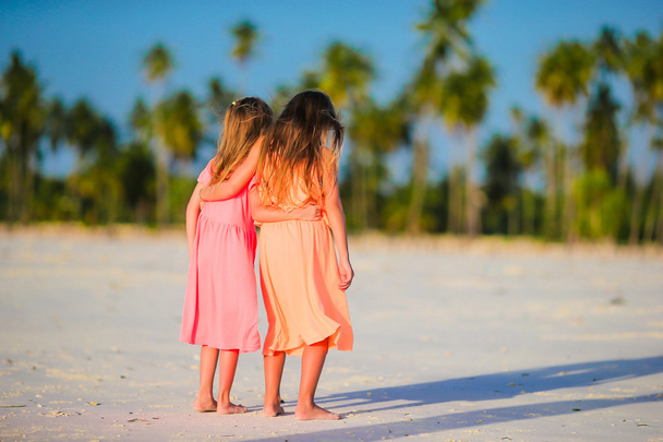 Pieniä valkoihoisia tyttöjä rannalla kesäloman aikana. Onnelliset lapset hauskaa yhdessä perheen kesälomalla
. - Valokuva, kuva