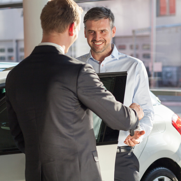 Mature man buying new car - Фото, изображение