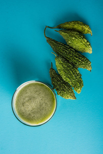Sumo de ervas de momodica verde num copo com legumes fatiados, sumo de karela ou sumo de cabaça amarga
 - Foto, Imagem