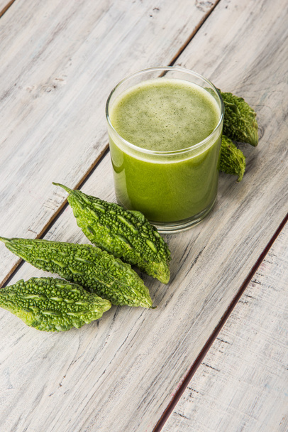 Травяной сок зеленой момомодики в стакане с нарезанными овощами, соком карелы или горьким соком тыквы
 - Фото, изображение