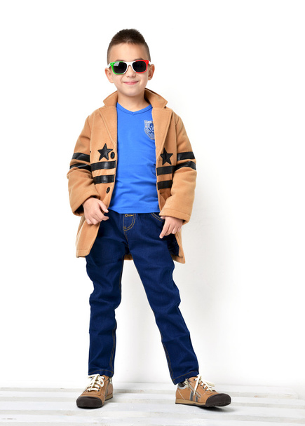 boy in orange brown clothing jacket and jeans standing in modern - Фото, изображение