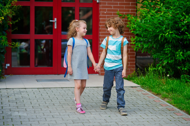 Boy and girlie go to school having joined hands. - Zdjęcie, obraz