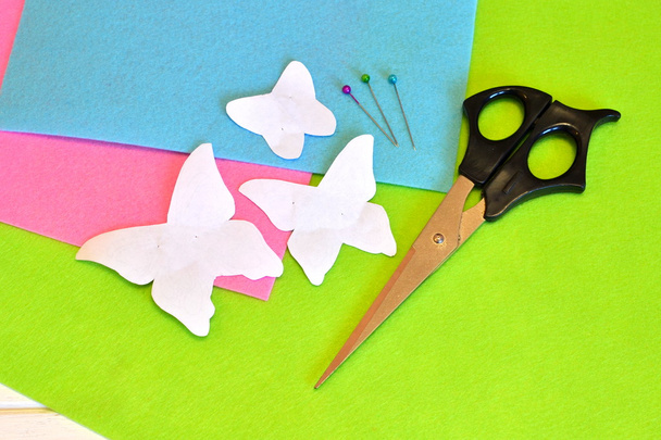 Modelos de papel borboletas, tesouras, alfinetes, lençóis de feltro. Conjunto de costura
 - Foto, Imagem