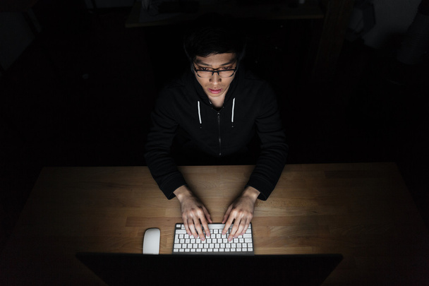 Top view of man using laptop in dark room - Фото, зображення
