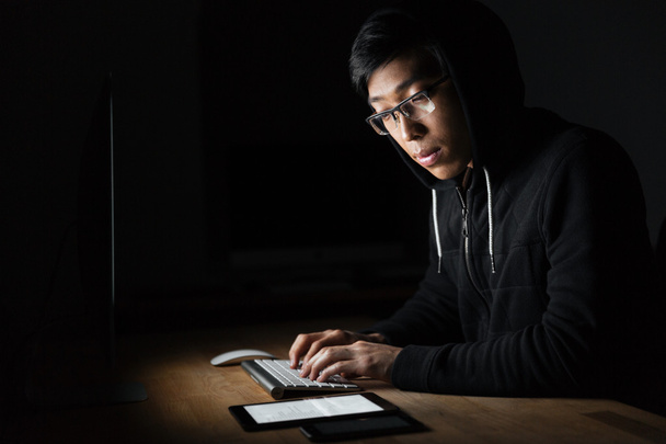 Hacker using laptop, tablet and smartphone in dark room - Zdjęcie, obraz