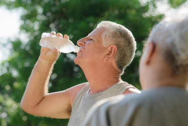 Senioren trinken Wasser nach Fitness im Park - Foto, Bild