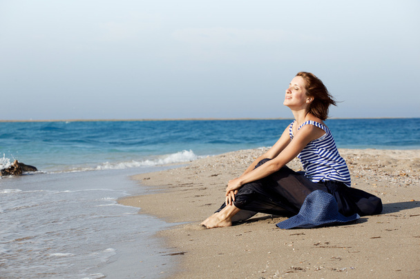 Красивая загорелая женщина отдыхает на пляже в летний день
 - Фото, изображение