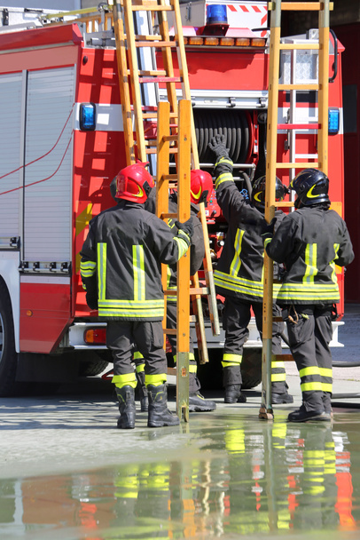οι πυροσβέστες σε ενέργεια να πάρουν τη σκάλα από το πυροσβεστικό όχημα - Φωτογραφία, εικόνα