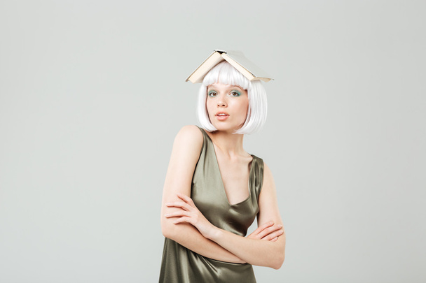 Funny cute young woman with book on her head - Fotoğraf, Görsel