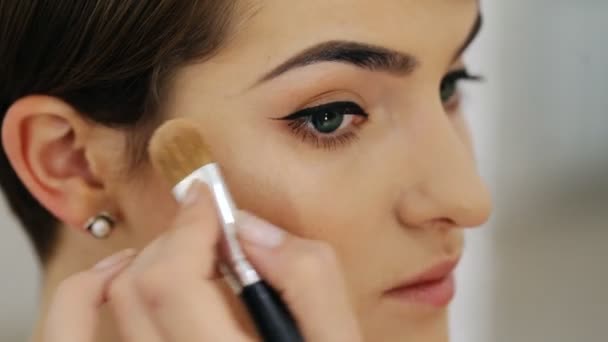 Menina modelo de moda bonita cujo artista de maquiagem aplicar iluminador, close-up
 - Filmagem, Vídeo
